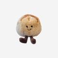 Plush toy resembling a sourdough bread with a face on a white background