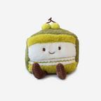 Plush toy resembling a slice of matcha cake with a green top on a white background